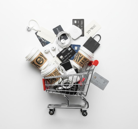 "Shopping cart filled with impulse purchase items and credit cards representing unnecessary spending habits"Unnecessary Purchases